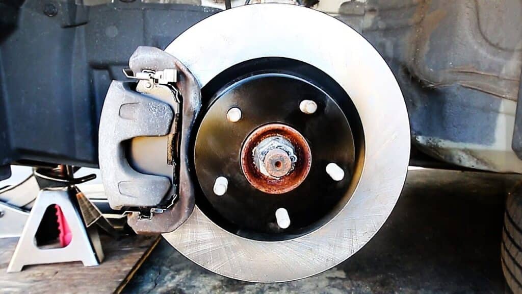 mechanic installing brake pads toyota