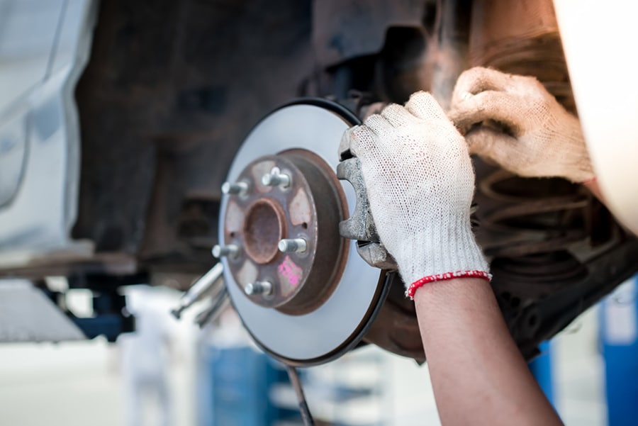 automotive mechanic installing brake pads town and country service